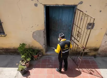 Técnico de Fumimaster fumigando la entrada de una casa para evitar la entrada de plagas.